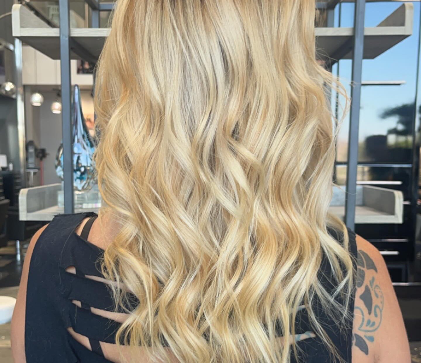 Long golden blonde hair with a lived-in root, curled into loose waves