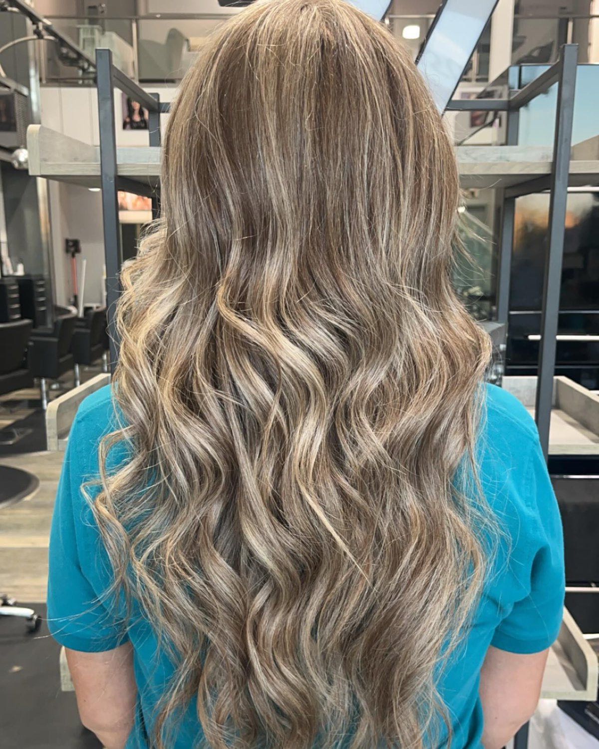 Long wavy hair with cool blonde highlights, styled and finished