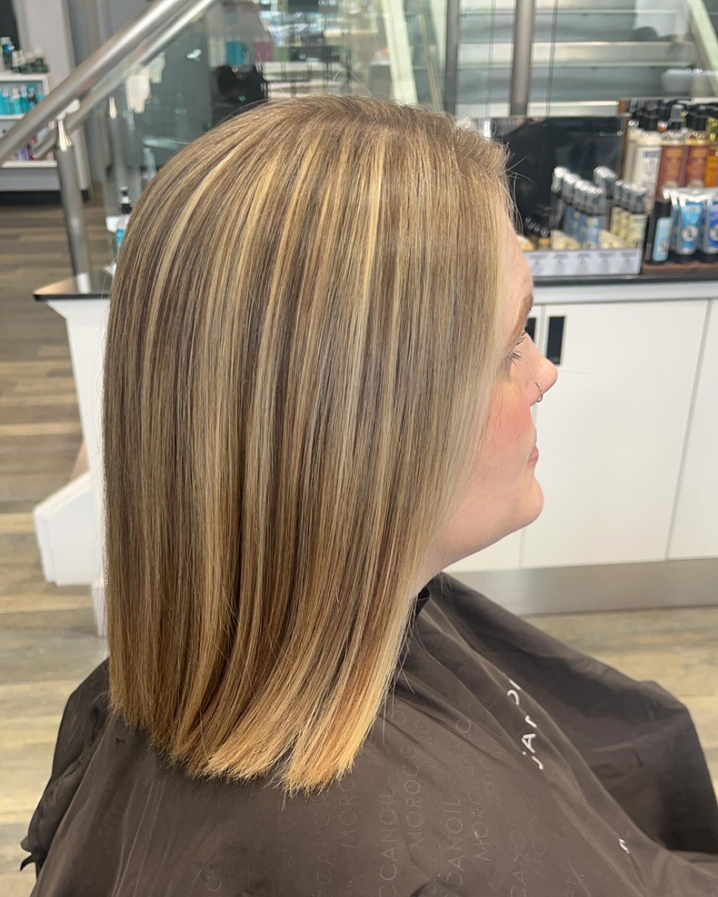 Blunt shoulder-length lob with fine blonde highlights, pressed straight